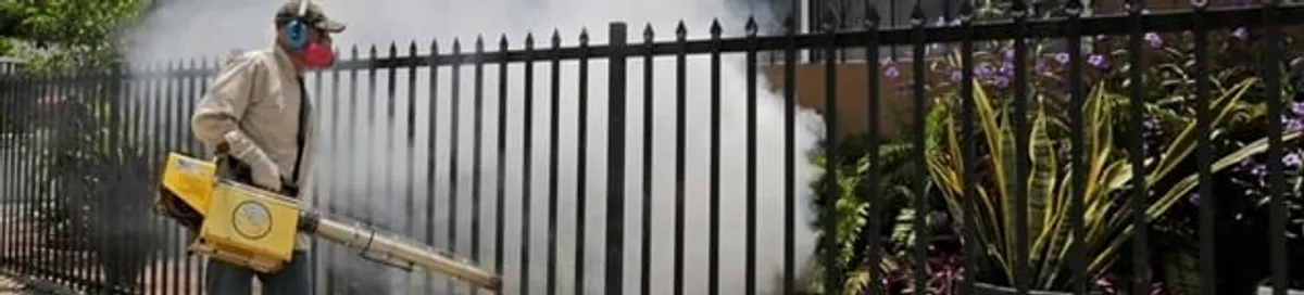 Mosquito control technician fogging a yard perimeter for mosquito reduction in Birmingham, AL